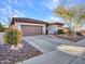 Single-story home with brown garage door and landscaped yard at 41933 N Crooked Stick Rd, Anthem, AZ 85086