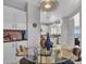 Bright kitchen with white cabinets, glass table, and view to living area at 41933 N Crooked Stick Rd, Anthem, AZ 85086