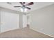 Bedroom with a ceiling fan, neutral carpet, closet doors, and open entry to hallway at 4628 W Hasan Dr, Laveen, AZ 85339