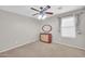 Bedroom with a ceiling fan, neutral carpet, window and a wooden dresser with mirror at 4628 W Hasan Dr, Laveen, AZ 85339