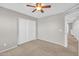 Bedroom with a ceiling fan, neutral carpet, and white closet doors at 4628 W Hasan Dr, Laveen, AZ 85339
