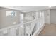 Upstairs hallway with white railing overlooking the staircase below, and a neutral carpet at 4628 W Hasan Dr, Laveen, AZ 85339