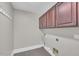 Functional laundry room with tile flooring, overhead cabinets, and washer and dryer hookups at 4628 W Hasan Dr, Laveen, AZ 85339