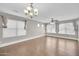 Bright living room with hardwood floors, two windows and an elegant chandelier at 4628 W Hasan Dr, Laveen, AZ 85339