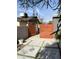 Modern orange wood gate opens to a paved backyard at 6307 E Gelding Dr, Scottsdale, AZ 85254