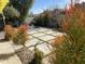 Landscaped backyard with tiled patio, plants, and seating at 6307 E Gelding Dr, Scottsdale, AZ 85254