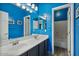 Shared bathroom with double sinks and blue walls at 9348 E Grandview St, Mesa, AZ 85207