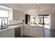 Eat-in kitchen boasts white cabinets, island, and backyard access at 9573 E Dreyfus Pl, Scottsdale, AZ 85260