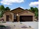 One-story home with a brown exterior, two-car garage, and landscaping at 13156 E Verbina Ln, Florence, AZ 85132