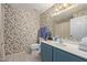 Small bathroom with floral wallpaper and blue vanity at 15225 N 100Th St # 1208, Scottsdale, AZ 85260