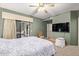 Bright bedroom with a ceiling fan, sliding door to patio, and large TV at 15225 N 100Th St # 1208, Scottsdale, AZ 85260