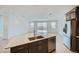 Stylish kitchen island with stainless steel sink and modern appliances and tile floors at 17603 W Superior Ave, Goodyear, AZ 85338