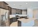 Contemporary kitchen with dark wood cabinets, stainless steel appliances, and center island at 17603 W Superior Ave, Goodyear, AZ 85338