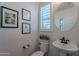 Clean bathroom with pedestal sink, toilet, and large mirror at 22633 E Domingo Rd, Queen Creek, AZ 85142