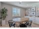 Bright dining area with round wooden table and four black chairs at 22633 E Domingo Rd, Queen Creek, AZ 85142