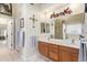Double vanity bathroom with wood cabinets and a large mirror at 23204 N Paseo Laredo Ln, Peoria, AZ 85383