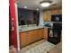 Kitchen with wood cabinets, black appliances, and breakfast bar at 2545 W Rose Ln # A-2, Phoenix, AZ 85017