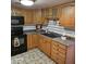 Kitchen with wood cabinets, black appliances, and tiled floor at 2545 W Rose Ln # A-2, Phoenix, AZ 85017