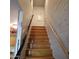 Indoor stairs with wood steps and a metal railing at 2545 W Rose Ln # A-2, Phoenix, AZ 85017