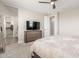 Bright bedroom with dresser, TV, and ensuite bathroom access at 26049 S 230Th St, Queen Creek, AZ 85142