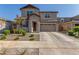 Two-story house with tan exterior, two-car garage, and landscaping at 26049 S 230Th St, Queen Creek, AZ 85142