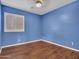 Blue walls, wood floor, ceiling fan, window with shutters in a bedroom at 29699 N 126Th Dr, Peoria, AZ 85383