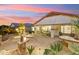 Expansive backyard patio with fire pit and seating area at sunset at 31538 N Larkspur Dr, San Tan Valley, AZ 85143