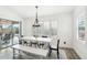 Bright dining room with white table, bench, and sliding door to patio at 3376 S 256Th Dr, Buckeye, AZ 85326