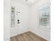 Bright entryway with white door, wood-look floors, and a glass block window at 3376 S 256Th Dr, Buckeye, AZ 85326