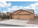 Tan house with a two-car garage and desert landscaping at 3376 S 256Th Dr, Buckeye, AZ 85326