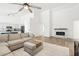 Open living room with L-shaped sofa, fireplace, and kitchen view at 3376 S 256Th Dr, Buckeye, AZ 85326