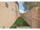 Landscaped side yard with artificial turf and block wall at 3376 S 256Th Dr, Buckeye, AZ 85326