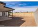 An expansive dirt backyard is enclosed by a tall block wall for privacy, with a covered patio at 5528 W Sunnyslope Ln, Glendale, AZ 85302