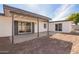 View of the white house exterior with gray trim and sliding glass doors leading to the yard at 5528 W Sunnyslope Ln, Glendale, AZ 85302