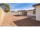 The backyard features a block wall, covered patio, and large dirt area with rear exterior home view at 5528 W Sunnyslope Ln, Glendale, AZ 85302