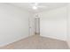 Simple bedroom featuring carpet, white walls, ceiling fan, and an open doorway at 5528 W Sunnyslope Ln, Glendale, AZ 85302