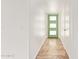 A bright hallway featuring tile flooring, a green front door, and white walls at 5528 W Sunnyslope Ln, Glendale, AZ 85302