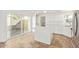 Well-lit kitchen with white cabinetry, quartz countertops, island, tile flooring, and stainless steel appliances at 5528 W Sunnyslope Ln, Glendale, AZ 85302