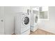 White washer and dryer units in a bright laundry room with tiled floors and white walls at 5528 W Sunnyslope Ln, Glendale, AZ 85302