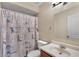 Bathroom with a floral shower curtain, toilet, and a vanity with a round mirror at 8328 W Fairmount Ave, Phoenix, AZ 85037