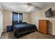 A modern bedroom with a bed, dresser, and window with natural light at 8328 W Fairmount Ave, Phoenix, AZ 85037