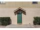 A close-up of the front door features a covered porch, green door, and manicured bushes at 8328 W Fairmount Ave, Phoenix, AZ 85037