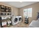 Bright laundry room featuring a washer, dryer, shelving, and a window for natural light at 8328 W Fairmount Ave, Phoenix, AZ 85037