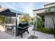 Pergola-covered outdoor kitchen with grill and bar seating at 9290 E Thompson Peak Pkwy # 422, Scottsdale, AZ 85255