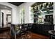 Home bar with marble countertop and black cabinetry at 9290 E Thompson Peak Pkwy # 422, Scottsdale, AZ 85255