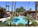 Community pool area features a covered patio, lounge chairs, desert landscaping and palm trees at 10426 N 11Th St # 3, Phoenix, AZ 85020