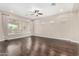 Spacious living room with dark hardwood floors and a ceiling fan at 1175 E Copper Holw, Queen Creek, AZ 85140