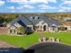 Expansive view of a luxurious home boasting mature trees and a perfectly maintained lawn at 1233 E Salado Cir, Mesa, AZ 85203
