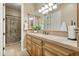 Elegant bathroom with light wood cabinets, tiled shower and large mirror at 1233 E Salado Cir, Mesa, AZ 85203
