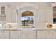 Kitchen features a farmhouse sink, white cabinets, and a window overlooking the pool at 1233 E Salado Cir, Mesa, AZ 85203
